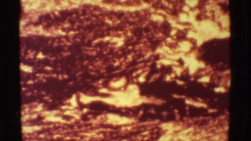 1971 8mm Mauna Ulu footage showing a soft, red-orange volcanic fire scene with dark terrain and heavy film grain.