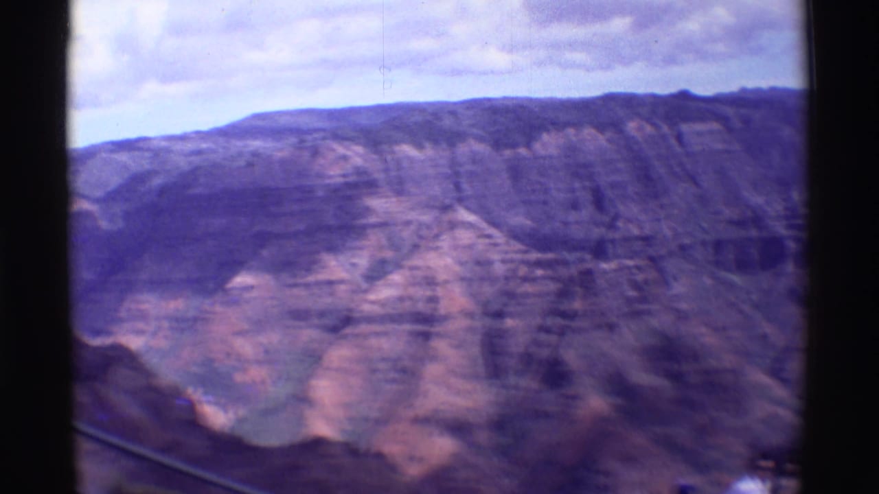 Canyon ridge and deep valley seen through dark film-frame borders.