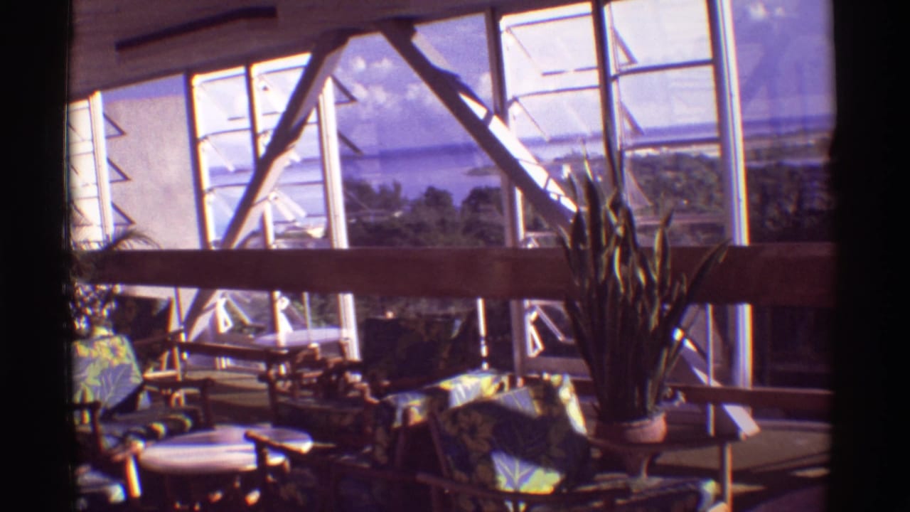 1971 Hawaii 8mm frame showing the restaurant from a slightly shifted angle, with tropical seating and landscape beyond the windows.