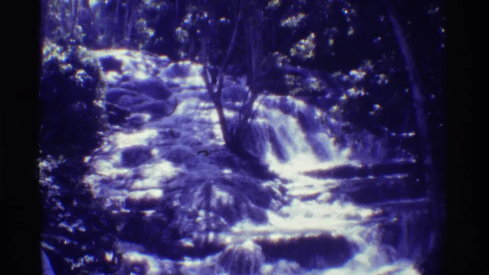 1971 Mauna Ulu, Hawaii 8mm frame showing a rocky stream stepping through small waterfalls beneath dense foliage.