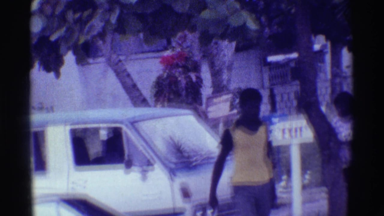 Man walking past a white van with an inn sign and building behind him.
