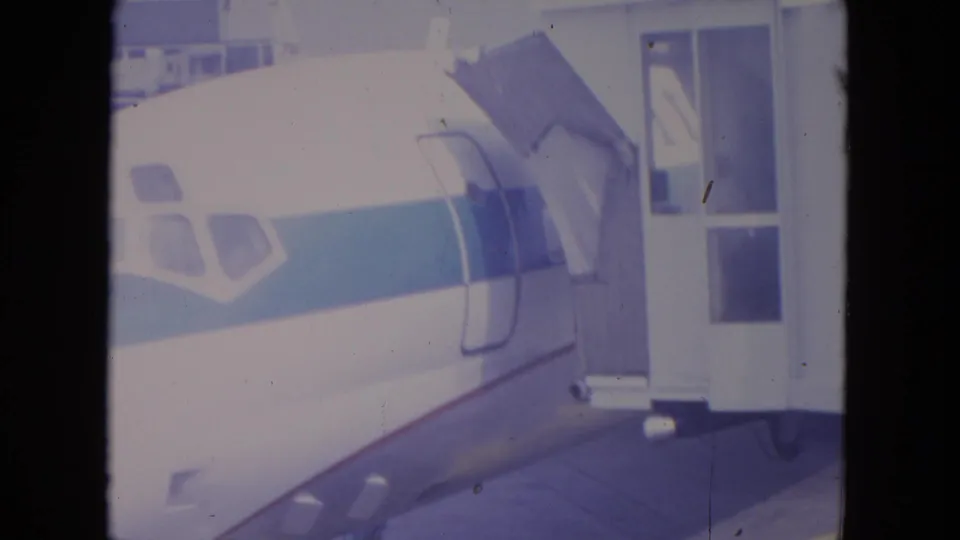 Close view of a commercial aircraft at O'Hare with the forward fuselage aligned beside a boarding stair or gate structure.