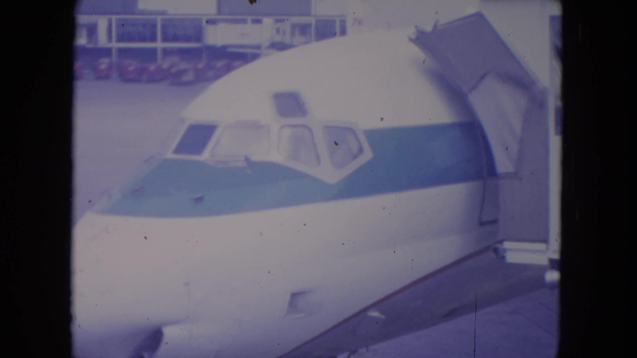1972 O'Hare home-movie view of the airliner front section as the jet bridge appears to move back from the aircraft.