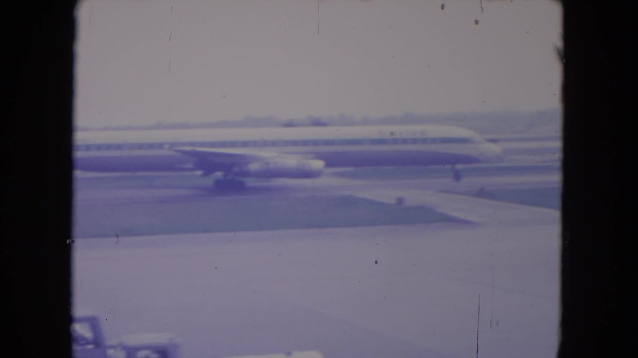 Side view of a passenger jet on the tarmac with runway pavement in front.