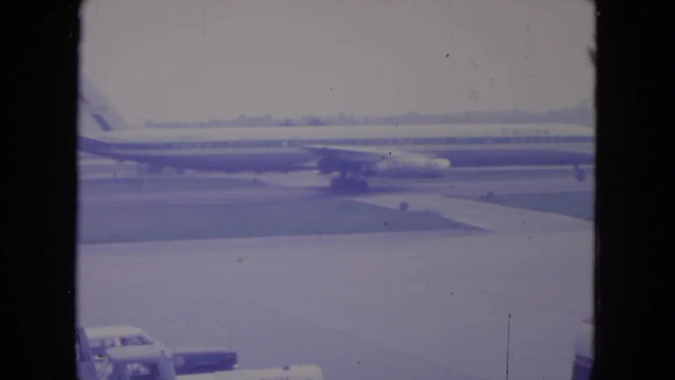 The United jet remains in view on the O'Hare tarmac while a car appears near the bottom edge of the 8mm frame.