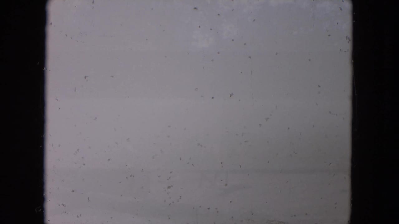 Mostly blank, pale film frame with dust and dark borders.