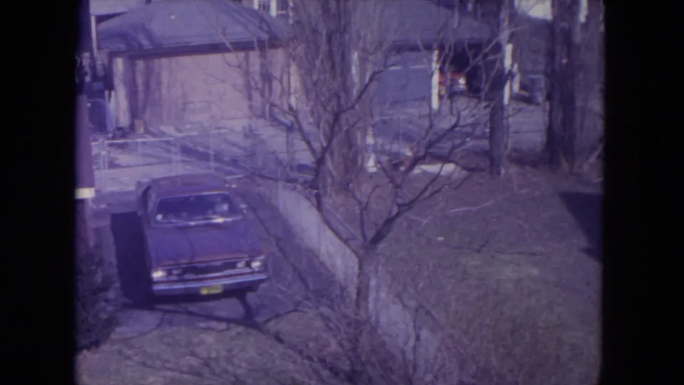 Older sedan in a residential driveway in 1972 Racine, Wisconsin 8mm footage.