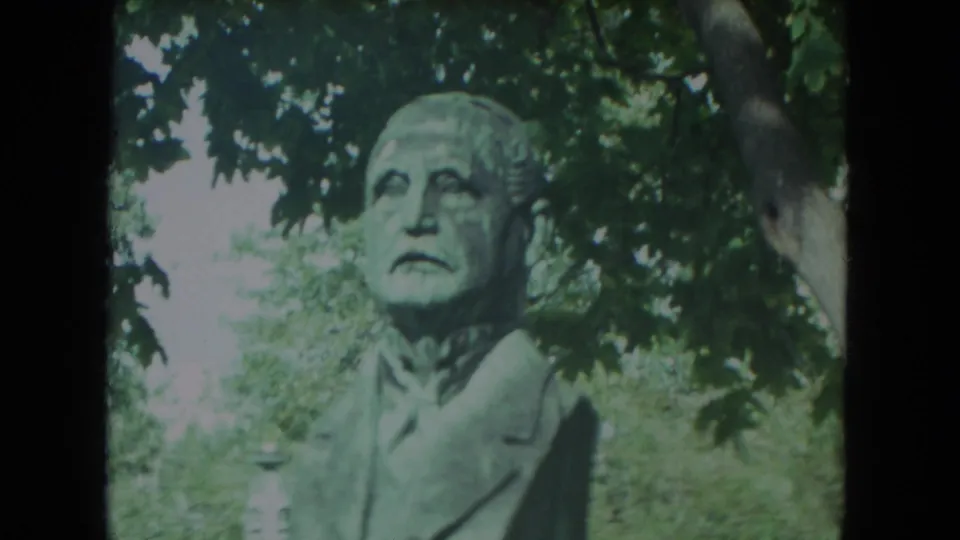 Weathered bronze male bust filmed outdoors in Racine, Wisconsin, in stated 1972 8mm home-movie footage.