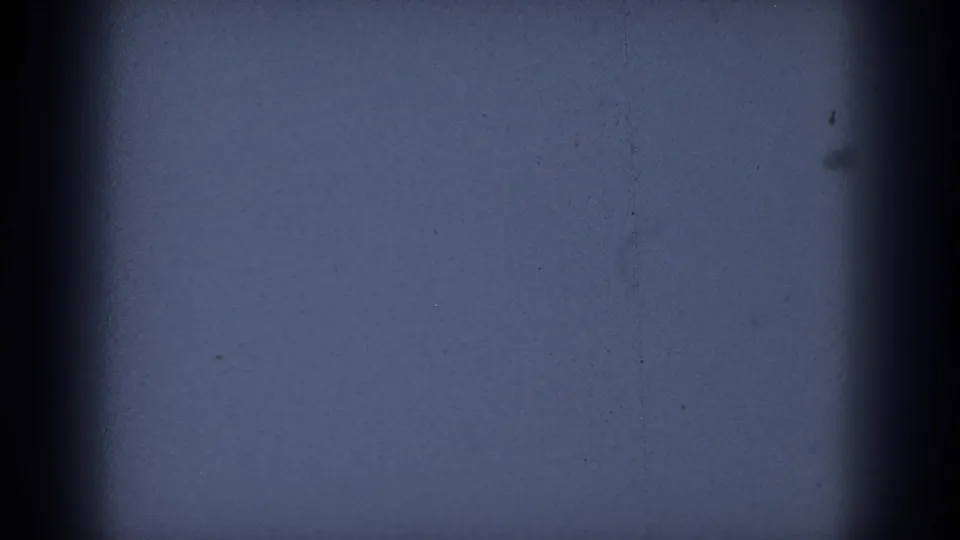 Final 8mm frame is largely out of focus and dark blue, with black side borders and small visible dust marks.