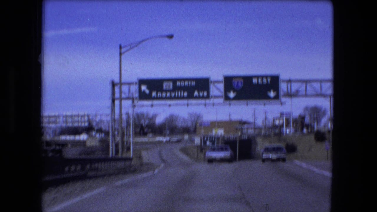 Roadway view with overhead signs for Knoxville Avenue and I-74 West.