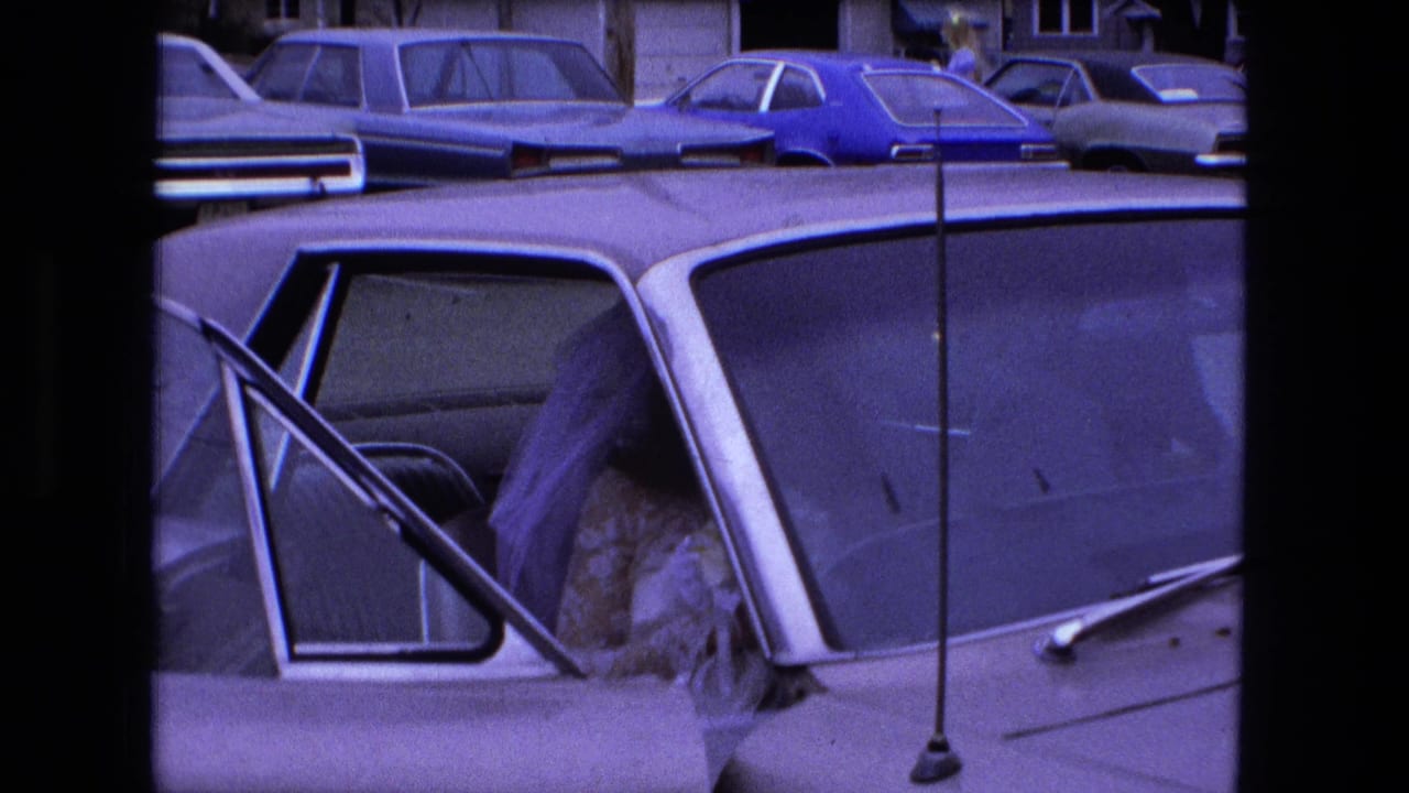 1973 Fort Wayne wedding footage frame with a woman in a white dress beside or inside a car with the door open.