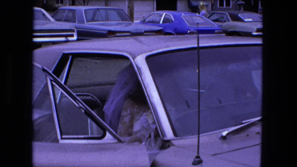 1973 Fort Wayne wedding footage frame with a woman in a white dress beside or inside a car with the door open.
