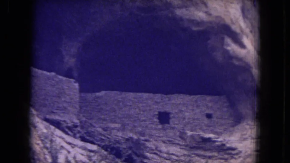 Weathered masonry ruins appear beneath a sandstone overhang in Gila National Forest, New Mexico, seen in soft 8mm color.