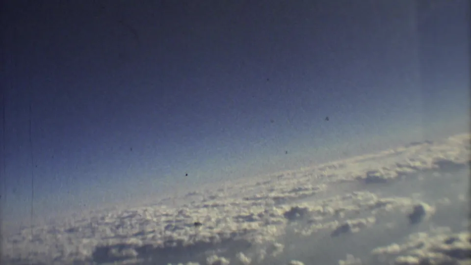 1973 8mm travel footage showing blue sky, haze, and a wide cloud layer viewed from an airplane near Mexico City.