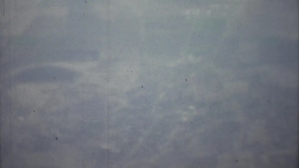 The final 1973 8mm frame shows a washed, hazy cloud field from above, with no people, aircraft markings, or ground features visible.
