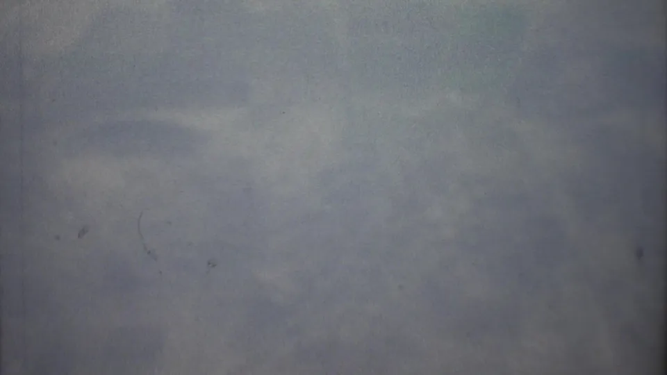 1973 Mexico City-linked 8mm frame showing an indistinct hazy view with muted color, grain, and small dust marks.
