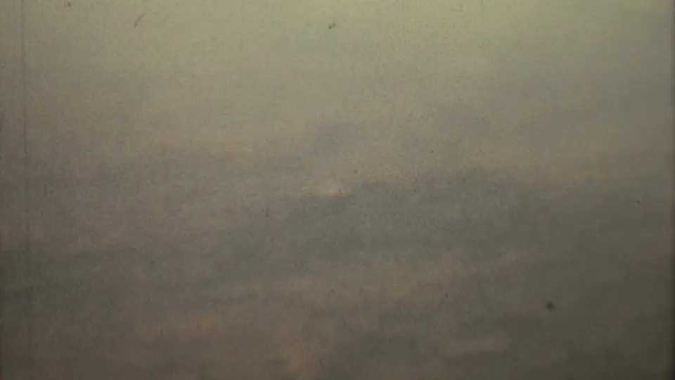 Overexposed 8mm frame from the 1973 Mexico City-linked clip, with green-gray haze and indistinct ground or sky bands.