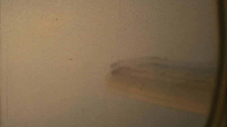 The airplane wing remains blurred in warm-toned 8mm footage, filmed from a passenger-window viewpoint in the 1973 Mexico City clip.