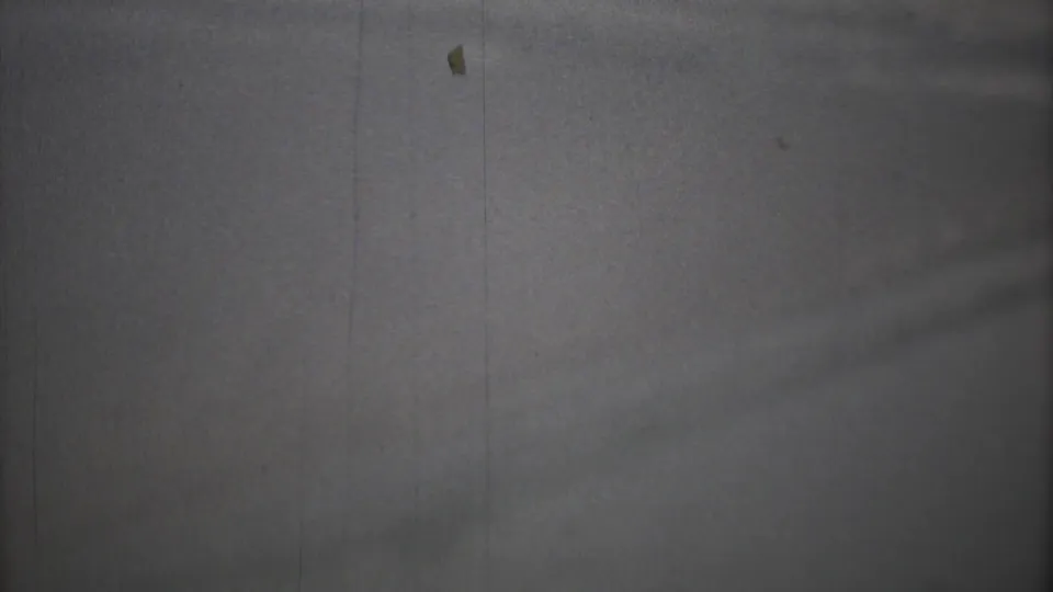 The final 8mm frame shows a dim, hazy airplane-window view with the wing barely visible at the right edge.