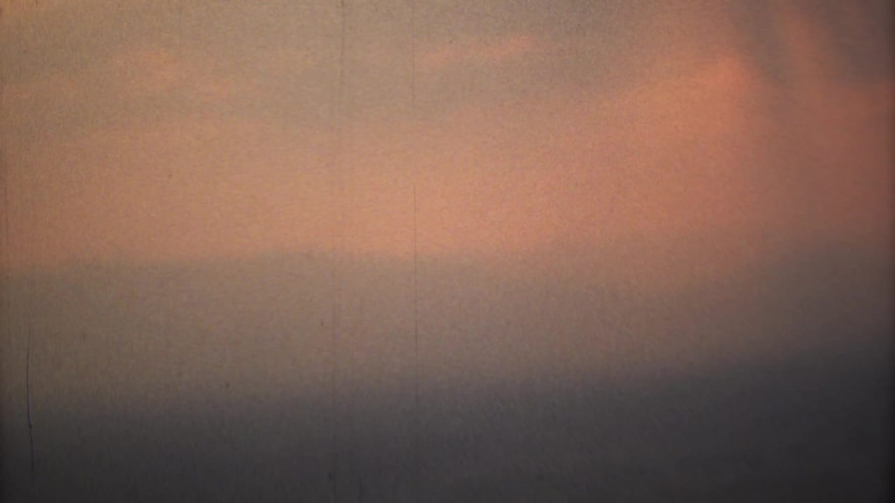 Orange and gray hazy sky with a dark horizontal band near the lower edge.