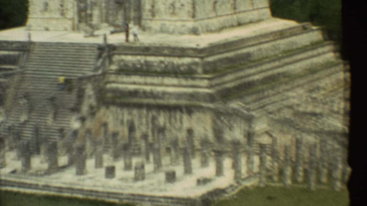 Distant visitors on steep stone steps beside tiered ruins.