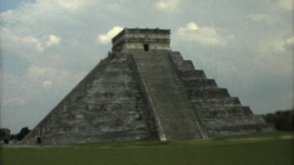 1973 8mm view of El Castillo at Chichen Itza, seen from the lawn with its stepped sides and summit temple visible.