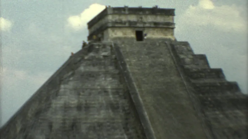 Closer 1973 Chichen Itza frame showing the steep stone face of El Castillo and the temple structure at the top.