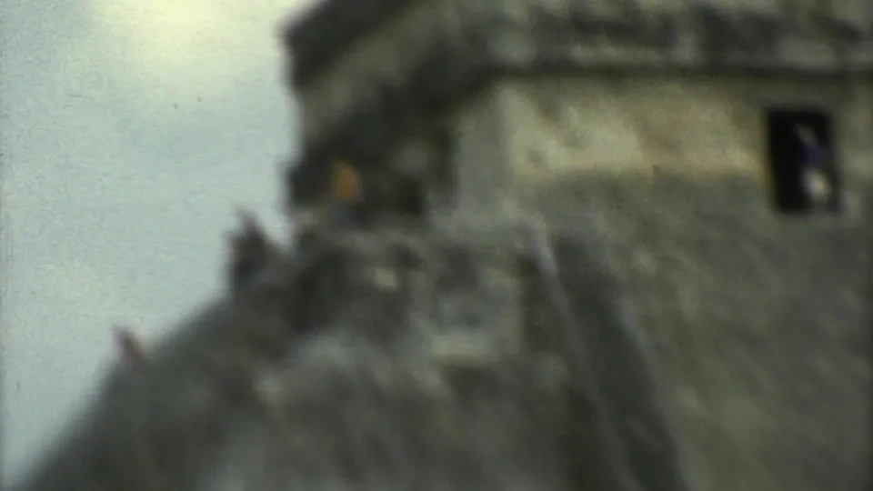 Soft-focused 1973 8mm close view of visitors climbing near the summit of El Castillo at Chichen Itza.