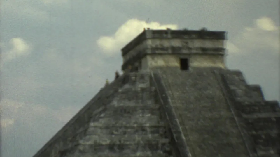 1973 8mm travel view of a stepped stone pyramid in Mexico, showing the summit temple and broad central stairway.