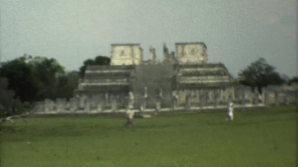 Final 1973 8mm frame holds on the grassy field, distant visitors, trees, and monumental stone ruins in Mexico City.