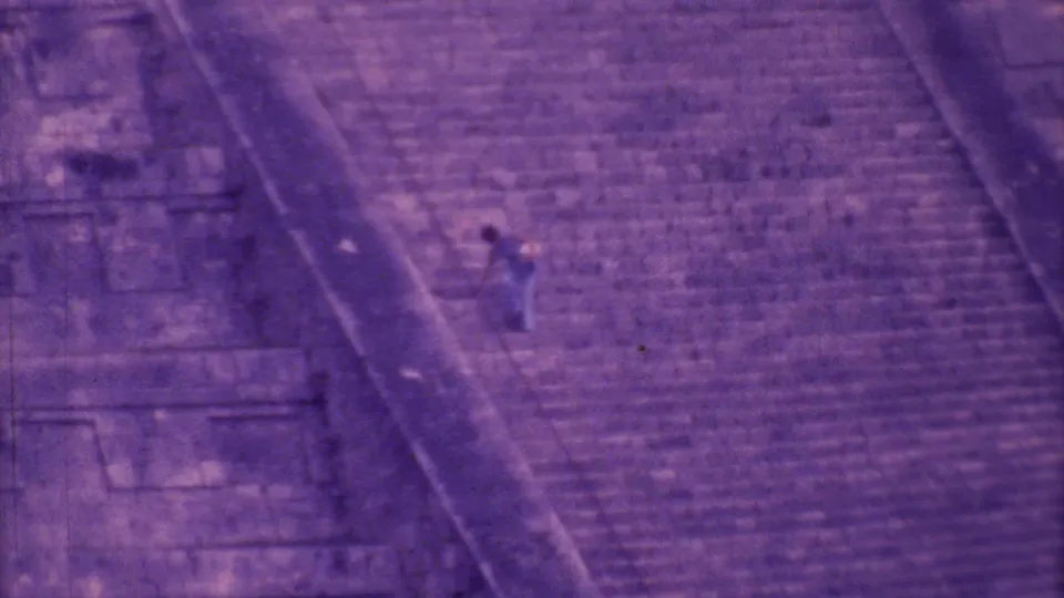 1973 Mexico City home-movie frame showing steep stone pyramid steps and a distant visitor moving down the structure.