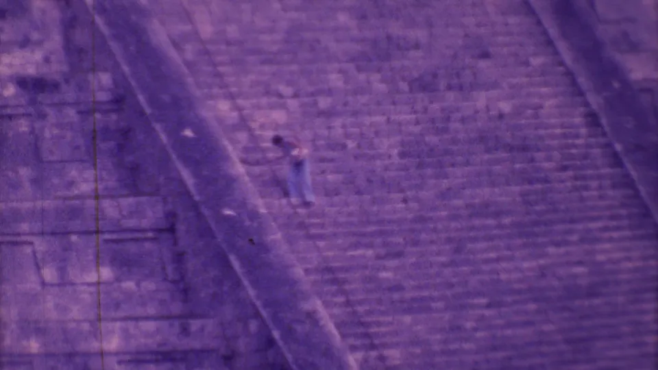A distant man descends the broad steps of a pyramid-like stone structure in 1973 Mexico City footage.