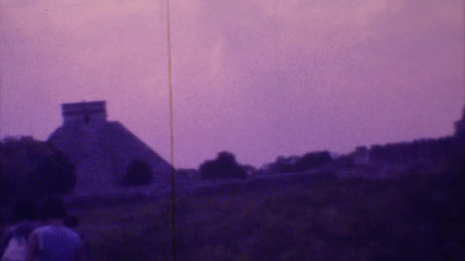 Visitors walk through a Mexico City ruin site in 1973, with a stepped pyramid-like structure visible ahead in grainy 8mm footage.