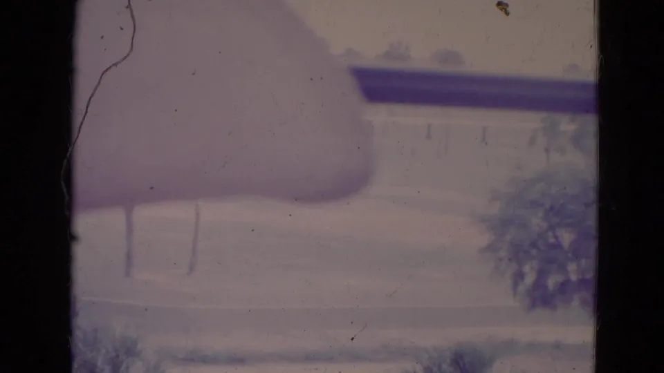 1974 Orlando-area aerial view with a dark aircraft wing or strut over faint rooftops, trees, and sun-faded 8mm texture.