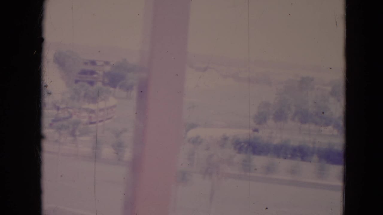Soft view of trees and shoreline seen through dark film-frame edges.