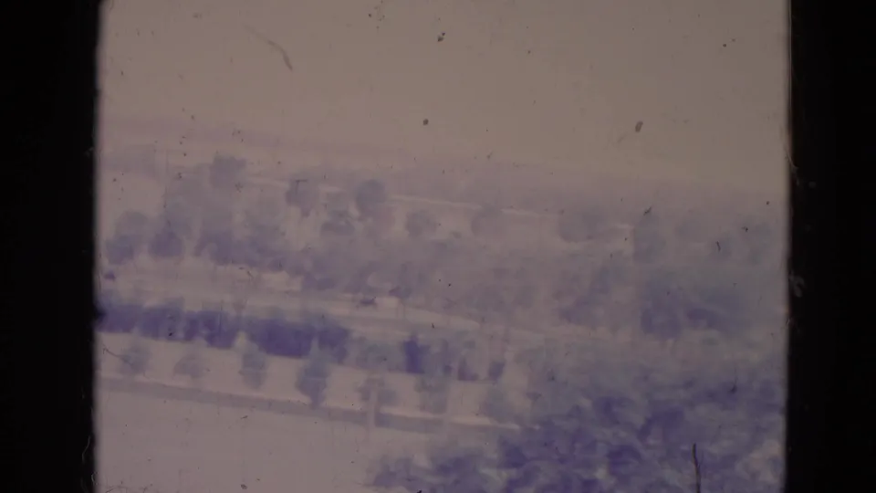 1974 Orlando river scene with distant trees, a low bank, and soft purple-pink fading across the 8mm image.