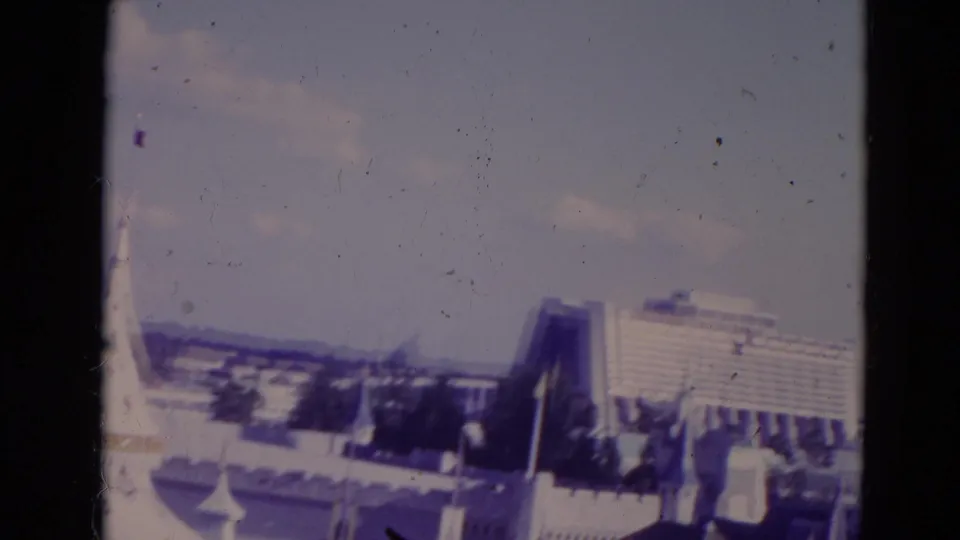1974 Orlando 8mm frame showing the Contemporary Resort area and nearby theme-park structures under a pale sky.