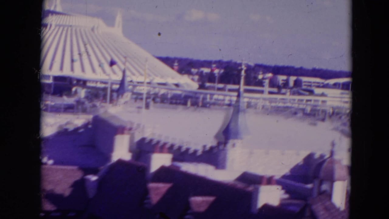 1974 Orlando frame with white castle-style roofs and turrets in the foreground and a ribbed circular pavilion beyond.