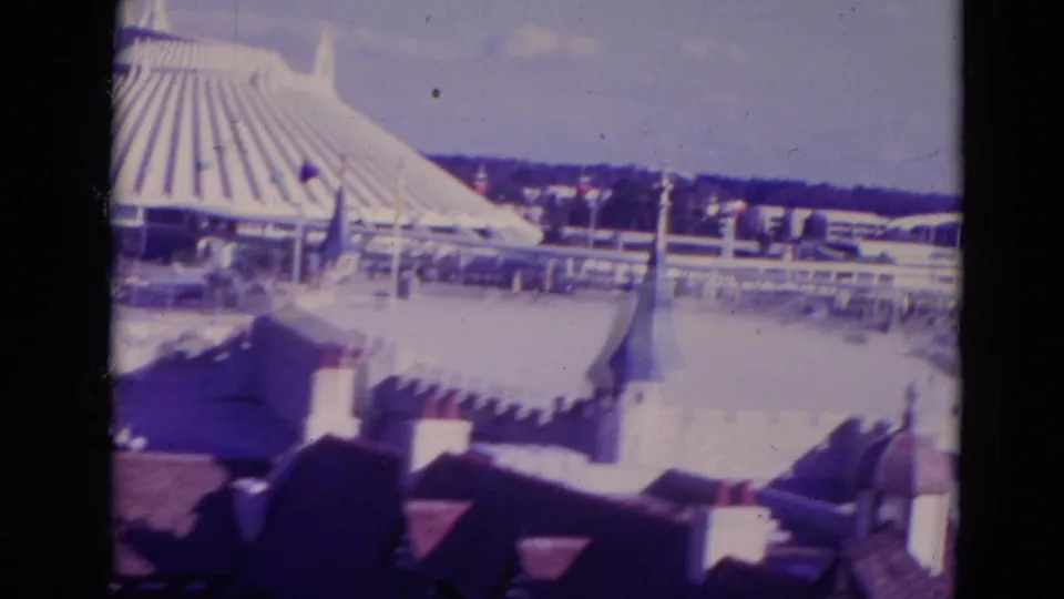 1974 Orlando frame with white castle-style roofs and turrets in the foreground and a ribbed circular pavilion beyond.