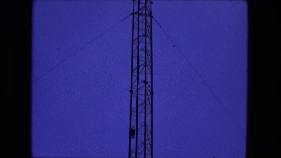 1974 Fort Wayne frame showing the tower higher in the tilt, with angled support wires stretching across a mostly clear blue sky.