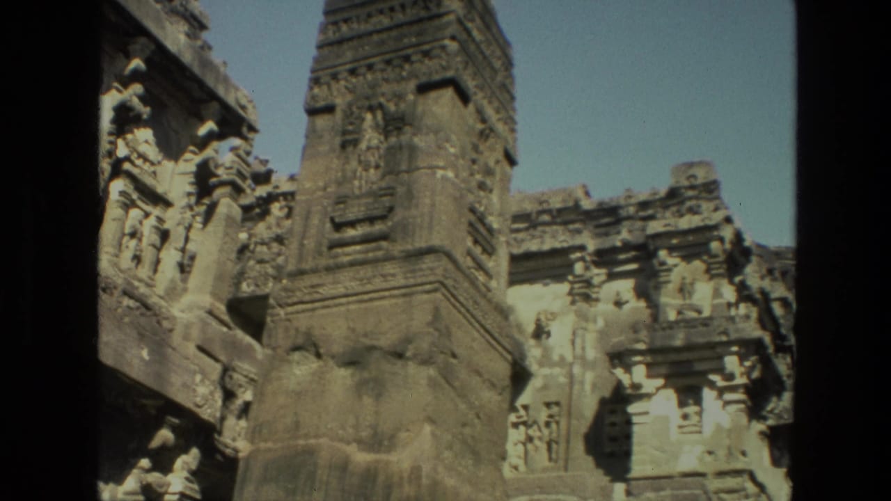 Carved temple spire and relief-covered stone facade in sunlight.