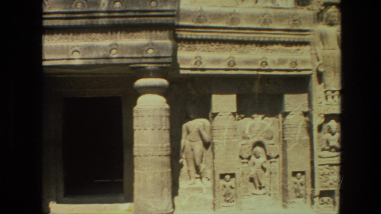 Temple doorway, carved pillar, and sculptural relief on a stone wall.