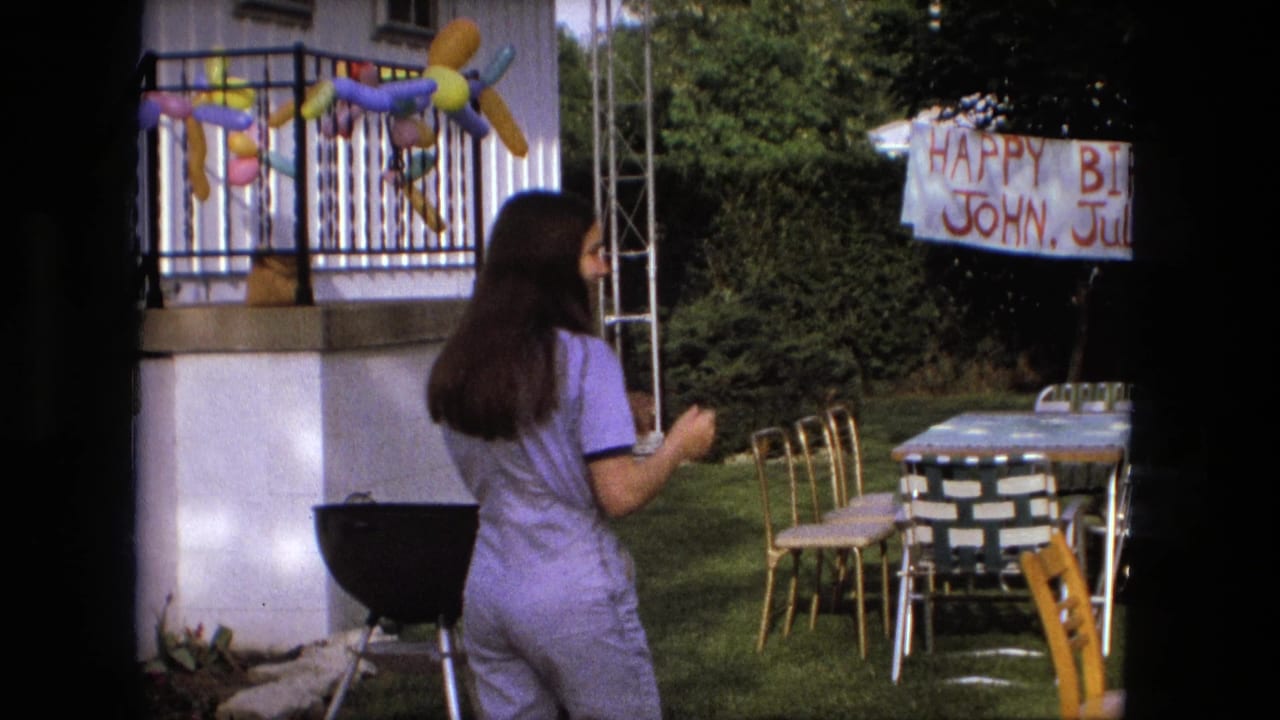 In a Fort Wayne, Indiana backyard in 1976, a young woman in a purple jumpsuit approaches tables and chairs beneath birthday decorations.