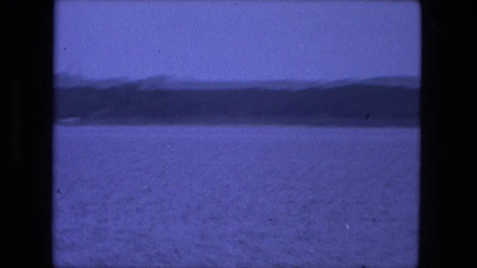 1974 Fort Wayne home-movie view of broad water, a low distant shore, and soft blue 8mm color.