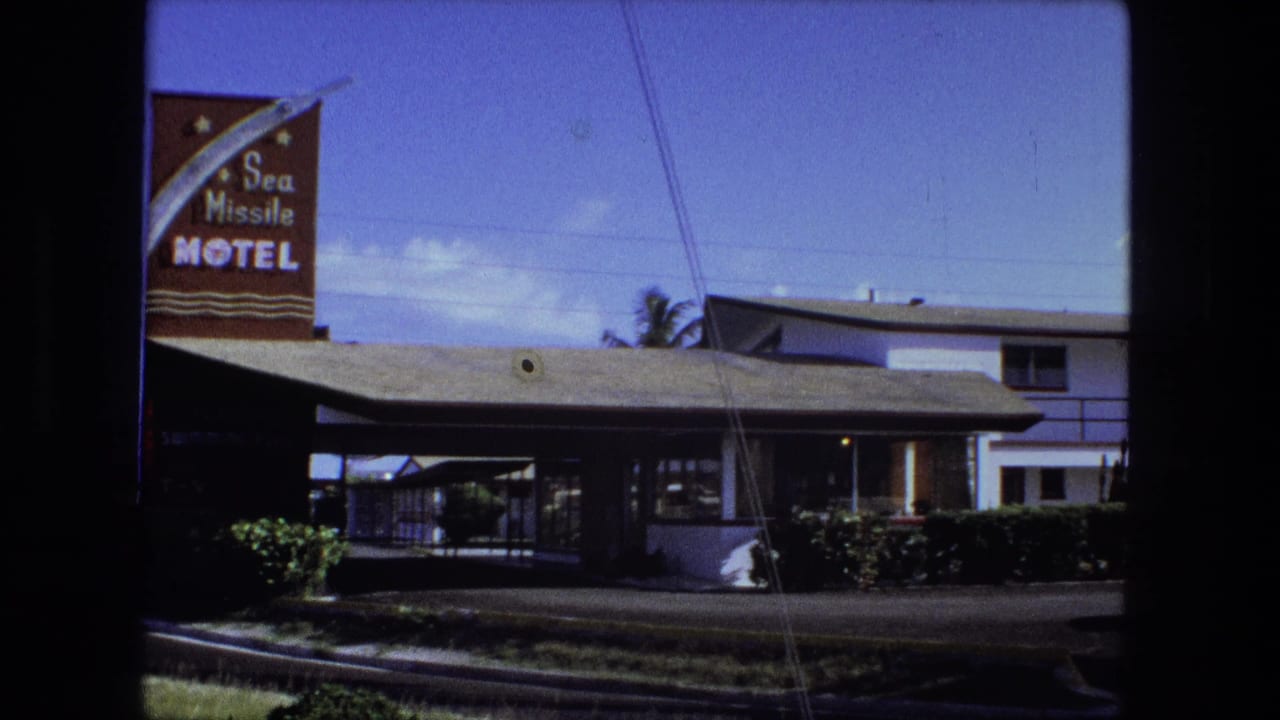 1974 Fort Wayne frame with the Sea Missile Motel sign, low roadside building, two-story guest wing, hedges, and overhead wires.