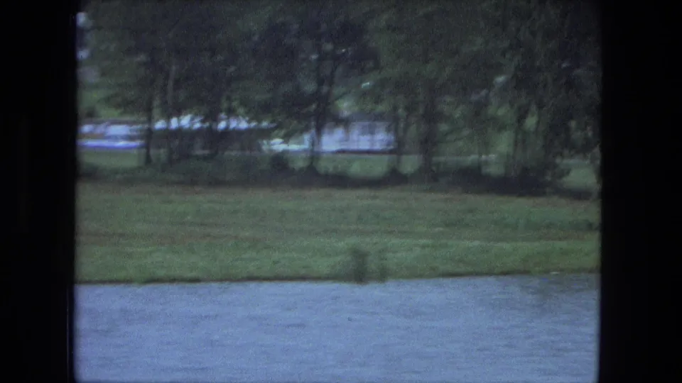Fort Wayne-area lakeside view from 1974, showing grass, trees, and water as the camera moves past.