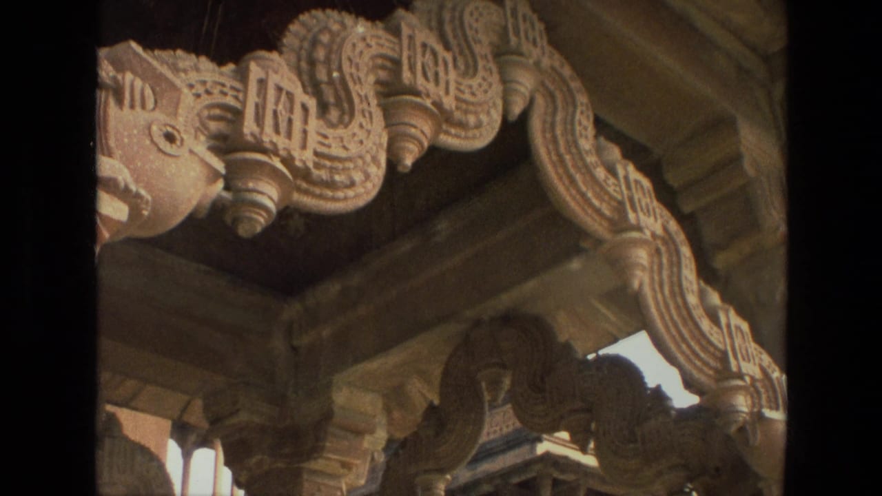 Close 1974 India travel frame of ornate carved stonework, scalloped arch forms, and shaded columns.