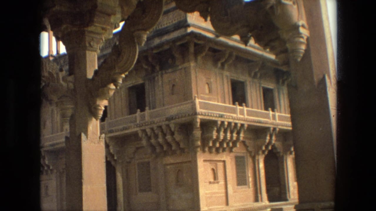 Temple facade seen between pillars, with carved brackets and small windows.