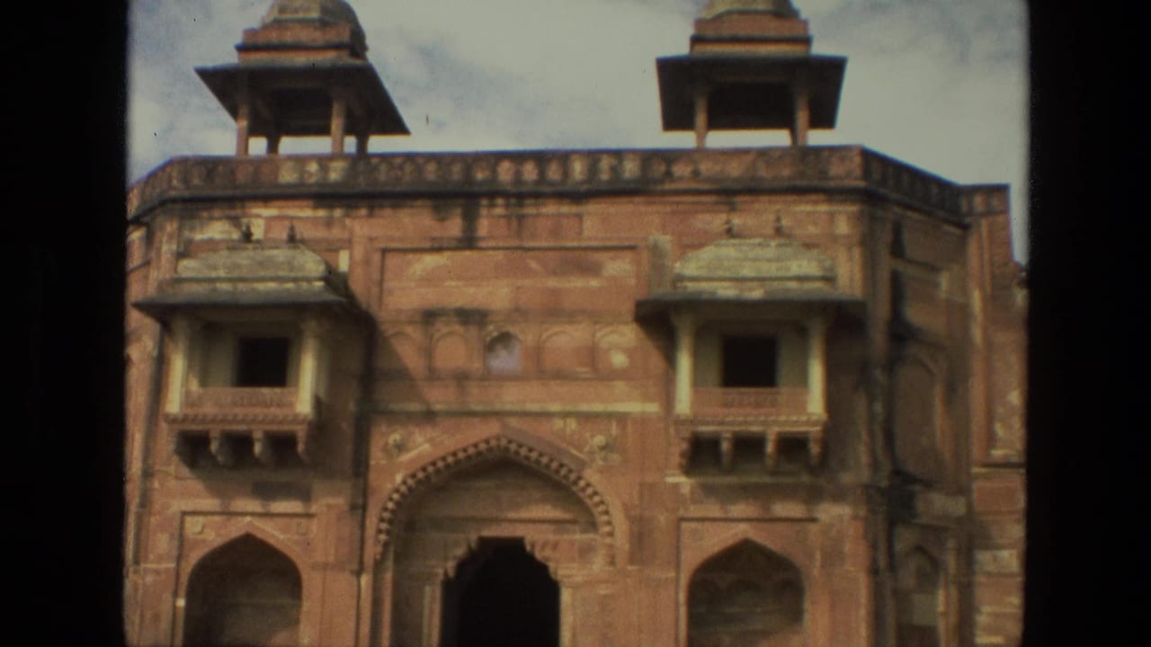 Closer view of the same red stone facade with arches and balcony windows.