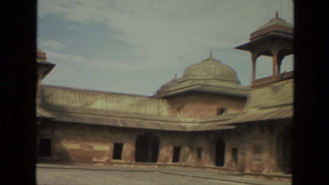 Long palace facade with domed roof structures and dark arched doorways.